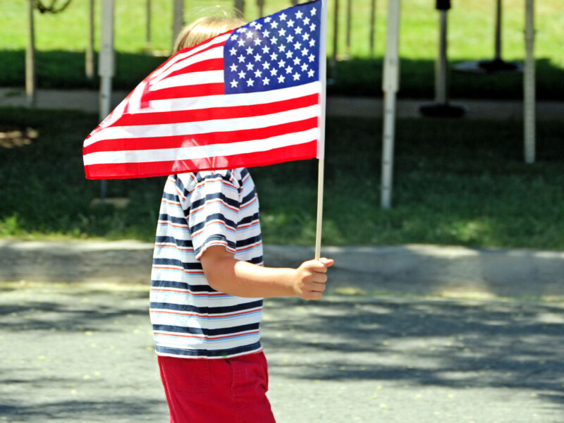 A child holds the American flag during an Independence Day celebration. (Creative Commons photo Ragettho/Wikimedia Commons)