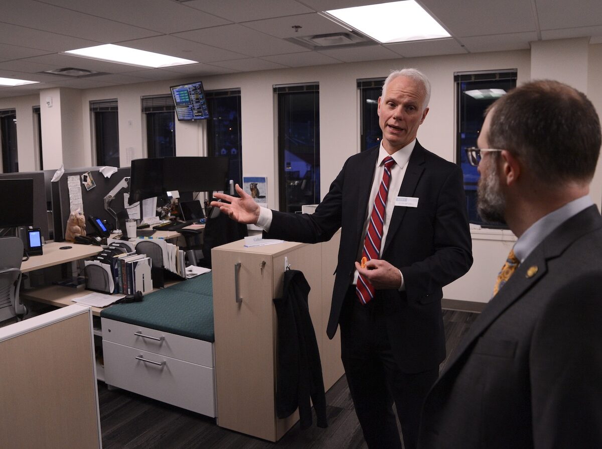 Deven Mitchell, executive director of the Alaska Permanent Fund Corp., gives a tour of the corporation’s investment floor to Sen. Jesse Kiehl, D-Juneau, and other attendees of an open house on Friday, Feb. 16, 2024. (Photo by James Brooks/Alaska Beacon)
