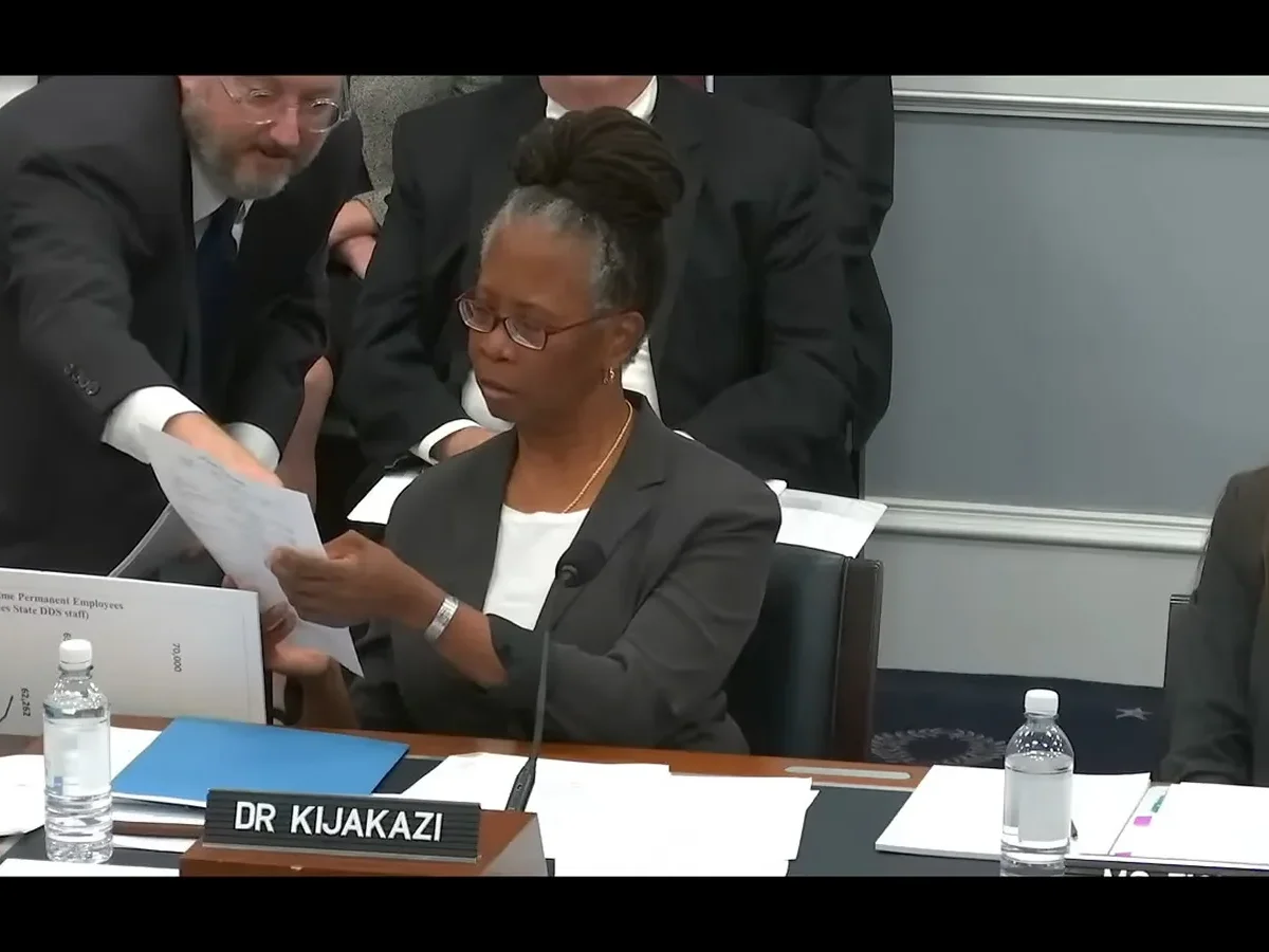 Tom Klouda, a deputy commissioner of the Social Security Administration, hands Kilolo Kijakazi, the agency’s acting commissioner, a piece of paper as she testifies at a House Ways and Means subcommittee hearing on Oct. 18 about the agency's payment clawbacks. (Screen shot courtesy/U.S. House Committee on Ways and Means)