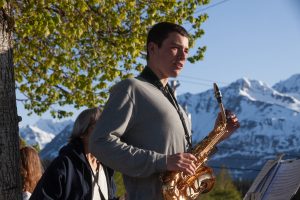 Colin Aldassy plays saxaphone with a band on the corner of Main Street during a senior graduation parade on Tuesday, May 21, 2024, in Haines, Alaska. (Rashah McChesney/Chilkat Valley News)