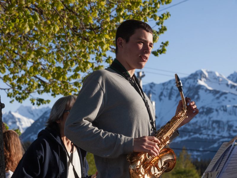 Colin Aldassy plays saxaphone with a band on the corner of Main Street during a senior graduation parade on Tuesday, May 21, 2024, in Haines, Alaska. (Rashah McChesney/Chilkat Valley News)