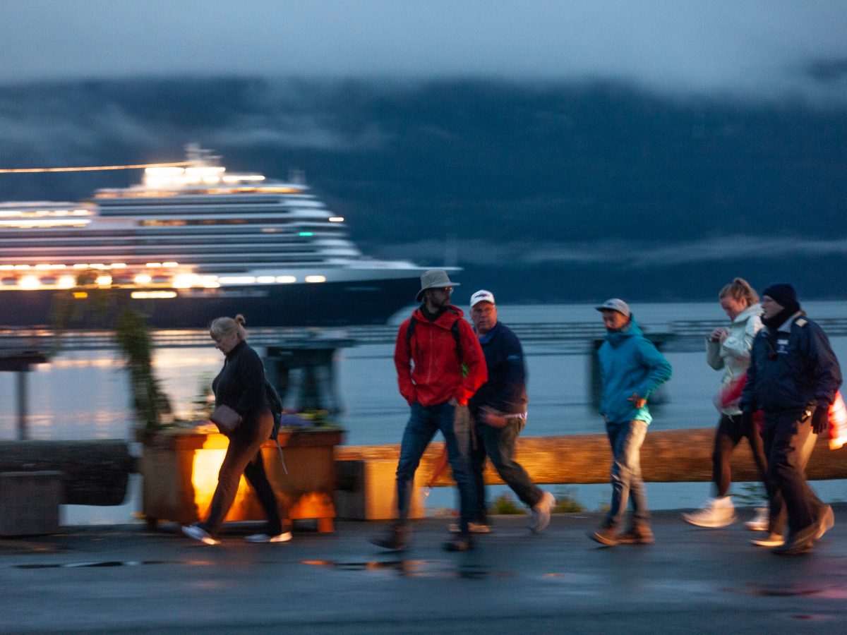 Passengers jump off of a bus and headed down Haines' cruise ship dock toward a nearby Holland America cruise ship on Wednesday, July 24, 2024, in Haines, Alaska. About 150 people, primarily cruise ship passengers who had disembarked in Skagway, were trapped by a landslide in Canada and then bussed several hundred miles to Haines to rejoin their cruises. (Rashah McChesney/Chilkat Valley News)