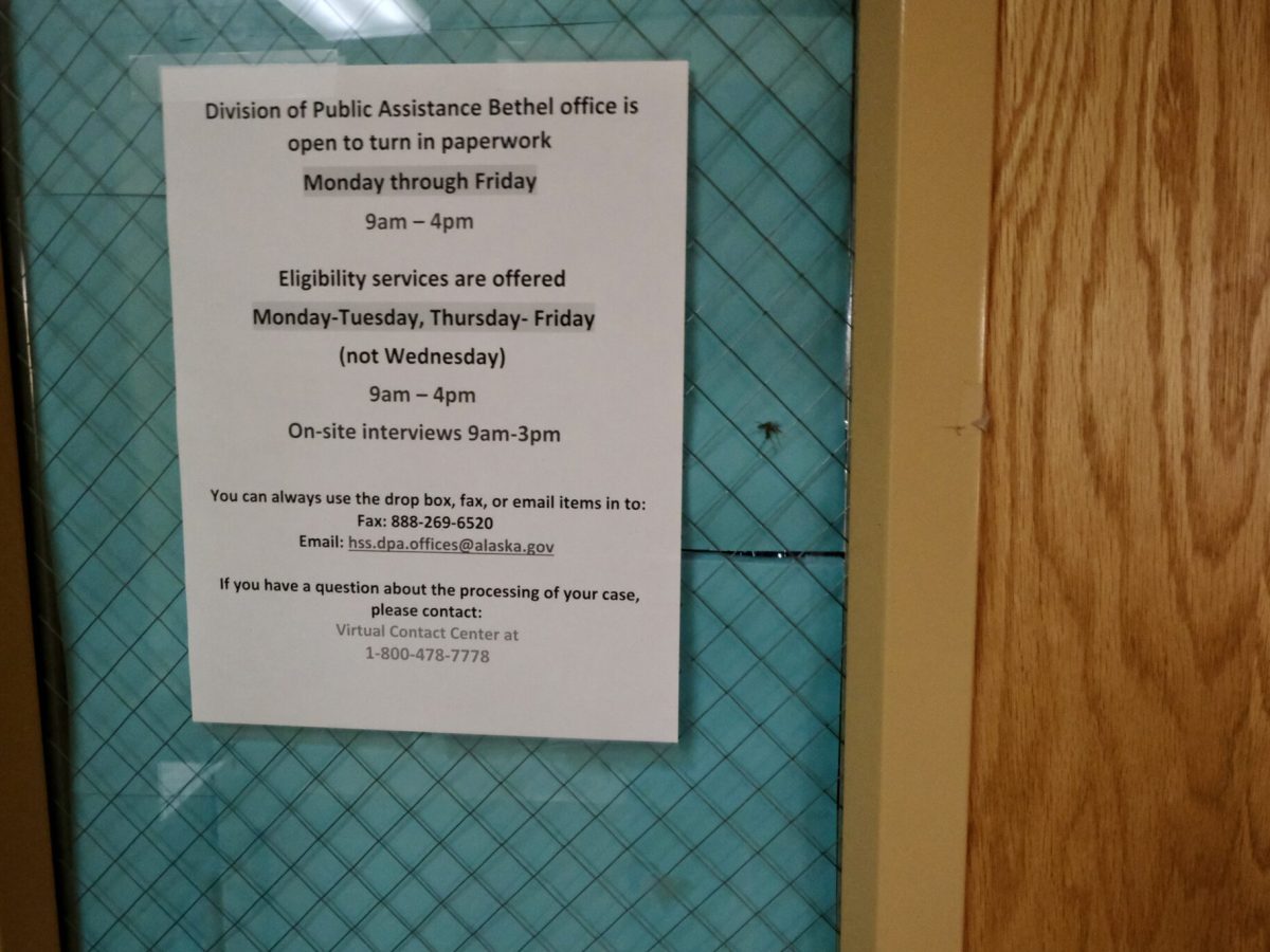 A sign posted on the door of the Division of Public Assistance office in Bethel, Alaska, on Oct. 11, 2023. The office offers full services. (Photo by Claire Stremple/Alaska Beacon)