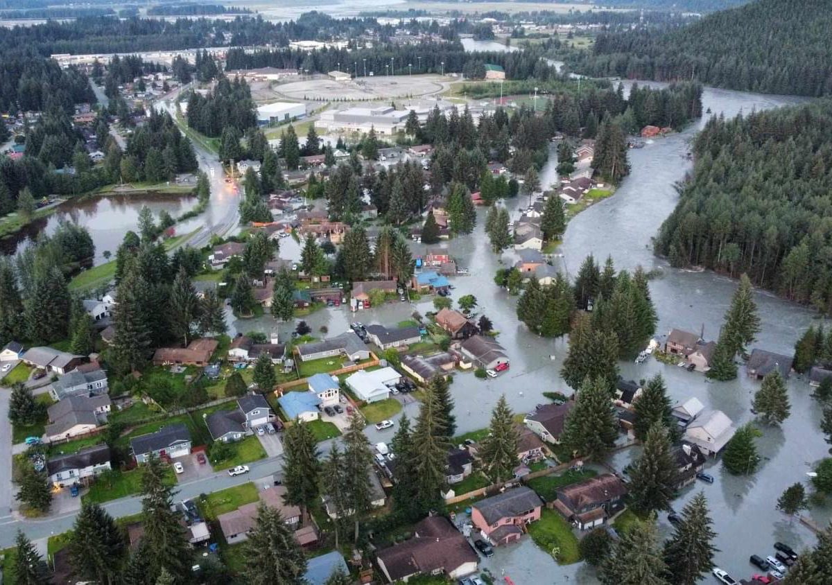 An aerial view of a river overflowing its banks and inundating dozens of homes in Juneau's Mendenhall Valley -- meant to show the scale of the damage.