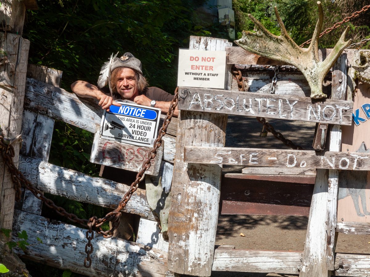 (Rashah McChesney/Chilkat Valley News) Steve Kroschel points to the signs on the front gate to his wildlife center on August 6, 2024, in Mosquito Lake, Alaska.