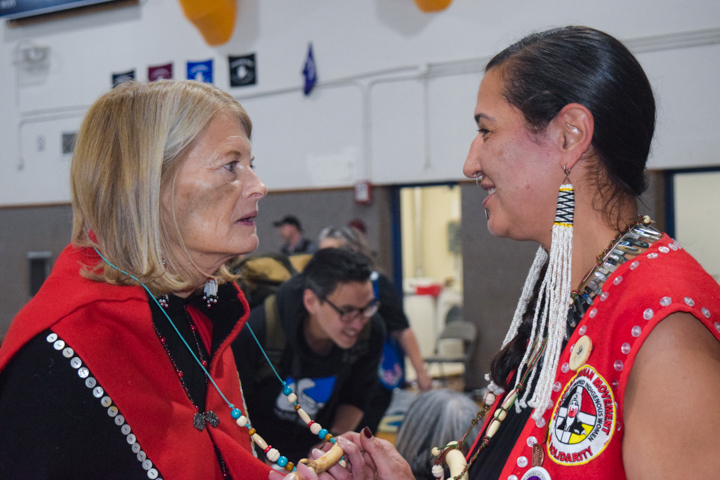Jamiann S’eiltin Hasselquist gifts Senator Lisa Murkowski a protection stick on behalf of the Ravens Bones House on Saturday, Oct. 26, 2024, in Angoon, Alaska. (Francisco Martínezcuello/Chilkat Valley News)
