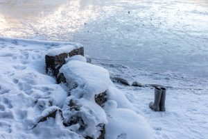 (Rashah McChesney/Chilkat Valley News) A pair of boots sit on the shore of Chilkoot Lake the day after a man who went ice skating fell through and disappeared on Thursday, Feb. 6, 2025, near Haines, Alaska.